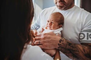 Newborn Photograph - parents hold their baby boy between them