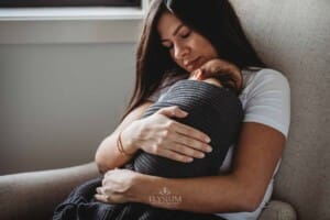Newborn Photograph - a mother holds her sleeping baby boy