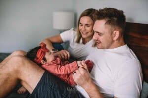 Newborn Photography - parents cradle their baby in their laps