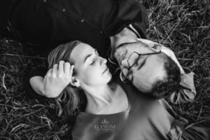 Engagement Photography - a couple hold each other as they lie in long grass