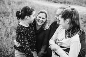 A family sit together and cuddle their mum