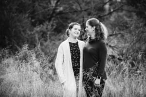 A mother stares lovingly at her daughter as they cuddle