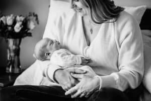 A mother cradles her newborn baby in her arms