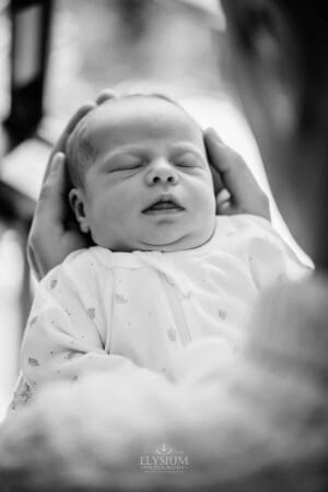 A mothers hands hold her newborn baby girl