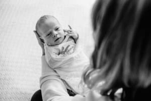 A mothers hands hold her newborn baby girl