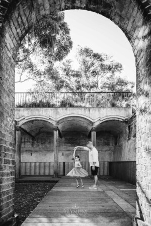 Paddington Gardens, a father holds his daughters hand and twirls her round