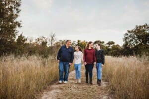 A family walk along a dirt path holding hands