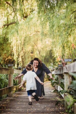 A little boy runs along a boardwalk to give his mum a hug