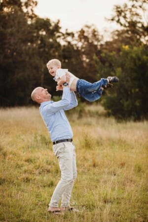 A father holds his son and whisks him through the air
