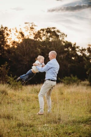 A father holds his son and whisks him through the air