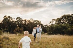 A little boy races towards his parents to give them a hug