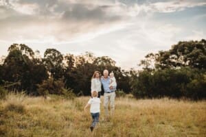 A little boy races towards his parents to give them a hug