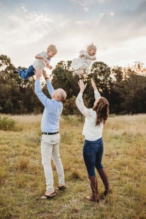 Parents toss their giggling children in the air above them