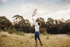 A mother tosses her giggling baby girl above her