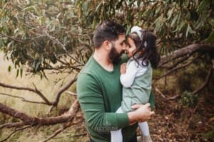 A father gives his daughter a little nose kiss