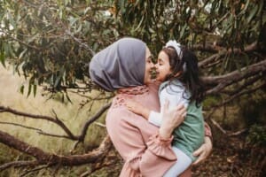 A little girl and her mother give each other nose kisses