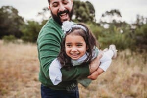 A father swings his daughter through the air