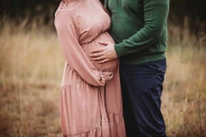 A man holds his pregnant wife's belly