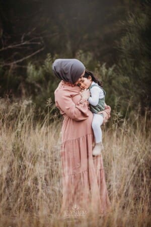 A pregnant mother cuddles her little girl