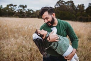 A father cuddles his little girl at sunset