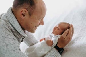 A father holds his newborn baby in his arms