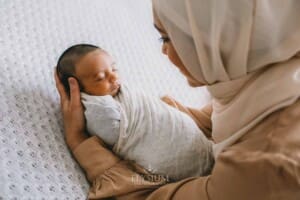 A mother holds her newborn baby in her arms