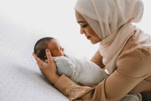 A mother holds her newborn baby in her arms