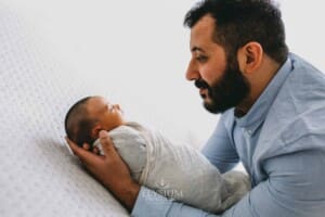 A father holds his newborn baby in his arms