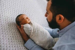 A father holds his newborn in his arms