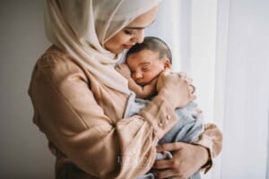 A mother holds her newborn baby in her arms