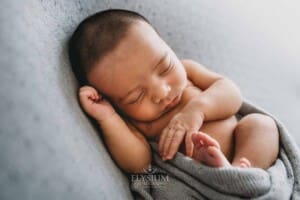 A newborn baby lays sleeping in a great wrap