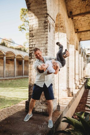 Paddington Gardens, a dad flips his son upside down as they laugh