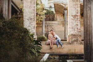 Paddington Gardens, a little brother and sister cuddle sitting on a step