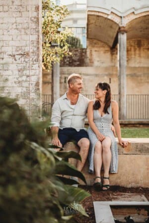 Paddington Gardens, parents cuddle sitting on a stone step