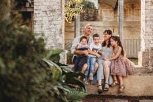 Paddington Gardens, a family sit huddled together on a stone step