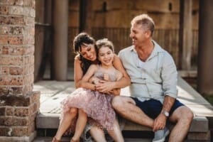 Paddington Gardens, parents hold their little girl in their lap for a cuddle