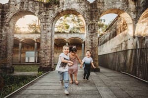 Paddington Gardens, children hold hands and run laughing