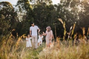 Parents swing their little girl up and down as they walk along