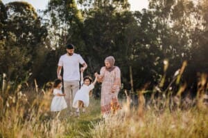 Parents swing their little girl up and down as they walk along