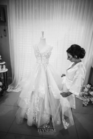Gledswood Wedding - a bride inspects her wedding dress hanging on a stand