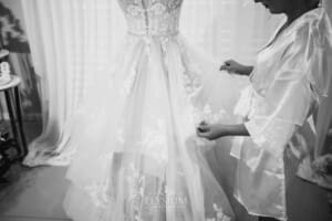 Gledswood Wedding - a bride inspects her wedding dress hanging on a stand