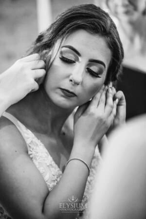 Gledswood Wedding - bride attaches her earing during morning prep