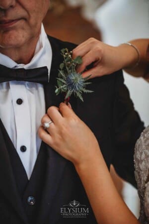 Gledswood Wedding - a bride attaches her fathers button hole flower