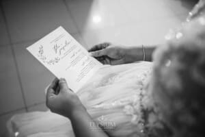 Gledswood Wedding - a bride holds her wedding invitation to read