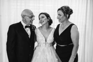 Gledswood Wedding - a bride stands hugging both her parents