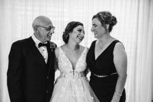 Gledswood Wedding - a bride stands hugging both her parents