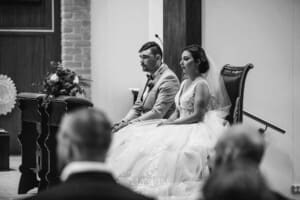 Gledswood Wedding - the bride and groom sitting at the front of the church during the ceremony