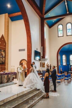 Gledswood Wedding - the bride and groom standing in front of their priest during the ceremony
