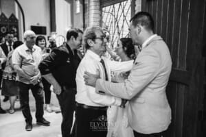 Gledswood Wedding - the groom hugs a wedding guest after the ceremony