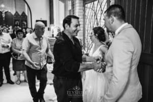 Gledswood Wedding - the groom hugs a wedding guest after the ceremony